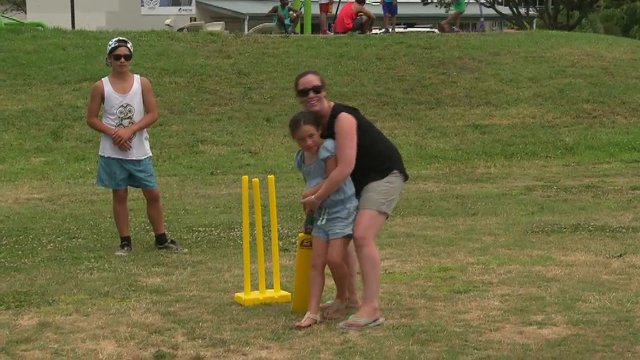 Mum playing cricket with daughter.