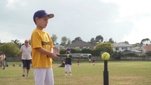 Boy swinging baseball bat learning fundamental movement skills