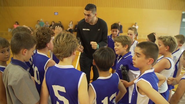 Children gather together as a team with coach.