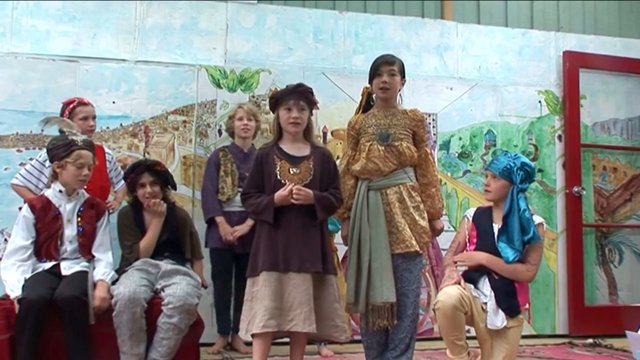 Children dressed up together performing play.