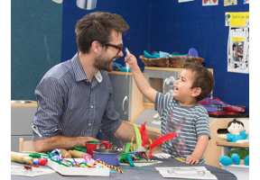 Robin Taylor sits with young child as the lead teacher at BestStart’s ABC Centre in Mt Eden.