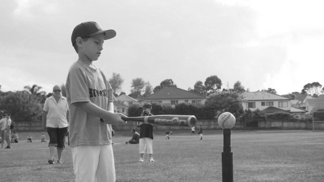 Boy swinging baseball bat learning fundamental movement skills