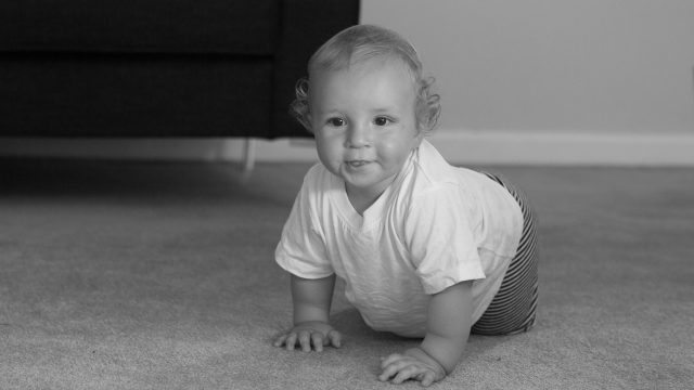 Baby crawling across floor.