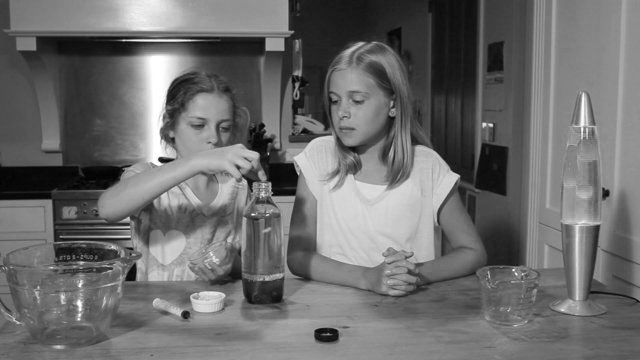 Two girls making a lava lamp.