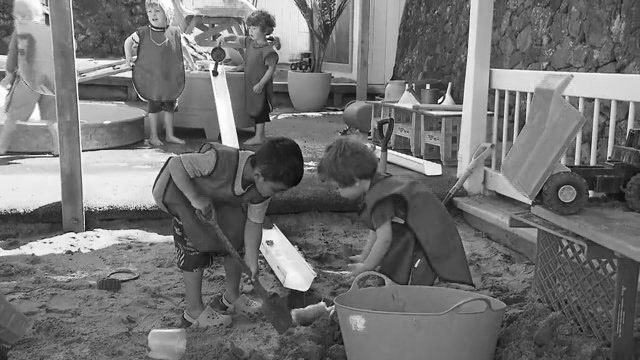 Young boys play in sandpit.