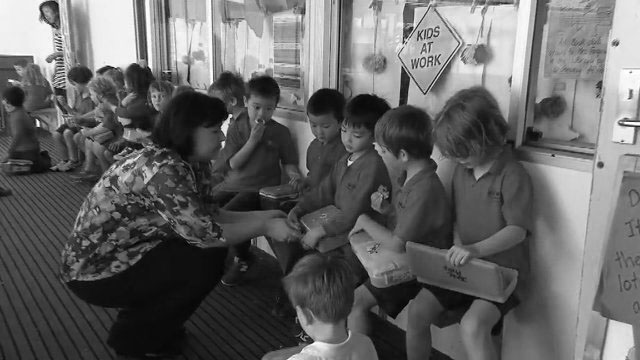 Early entrant school children sit having lunch.